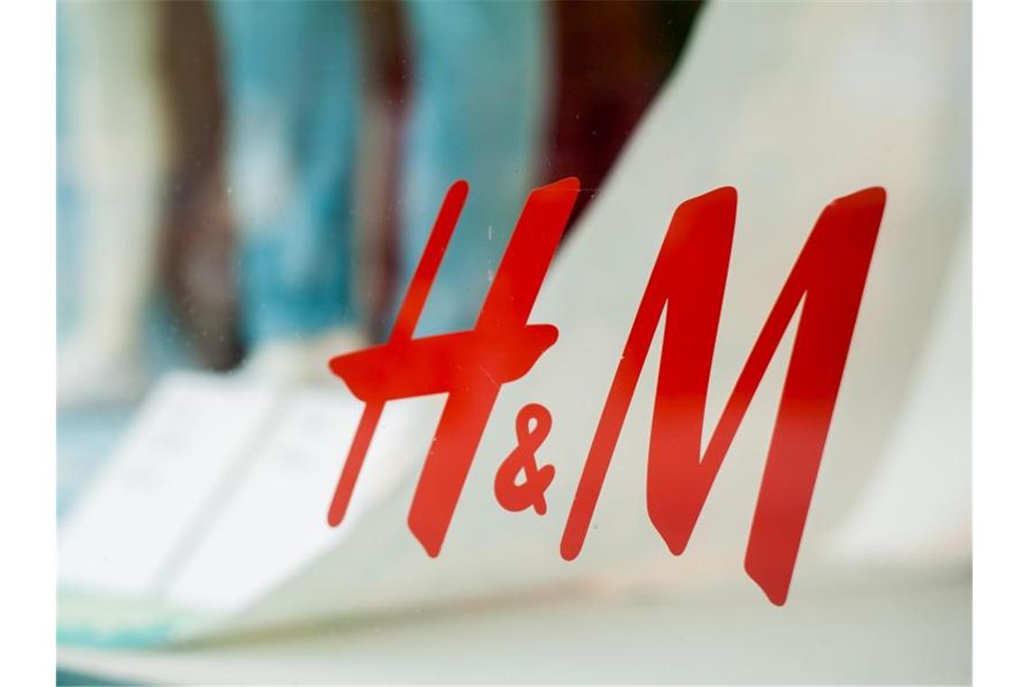 Das Logo der Bekleidungskette Hennes und Mauritz (H&M) klebt am Schaufenster einer Filiale am Kurfürstendamm in Berlin. Foto:  Hauke-Christian Dittrich
