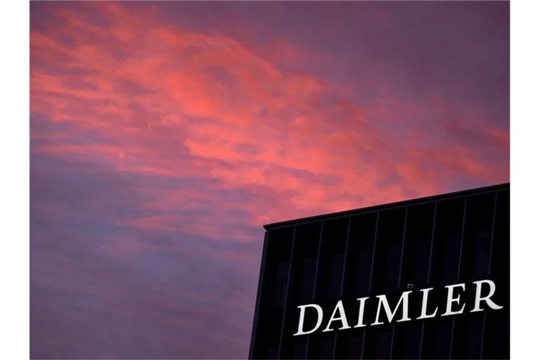 Das Logo der Daimler AG ist in der Morgendämmerung auf der Zentrale des Autokonzerns zu sehen. Foto: Marijan Murat/dpa/Archivbild