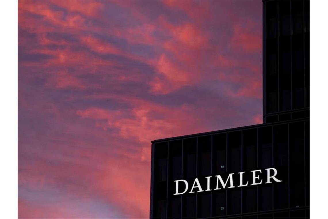 Daimler schickt Tausende Mitarbeiter in Kurzarbeit Das Logo der Daimler AG ist in der Morgendämmerung auf der Zentrale des Autokonzerns zu sehen. Foto: Marijan Murat/dpa/Archivbild