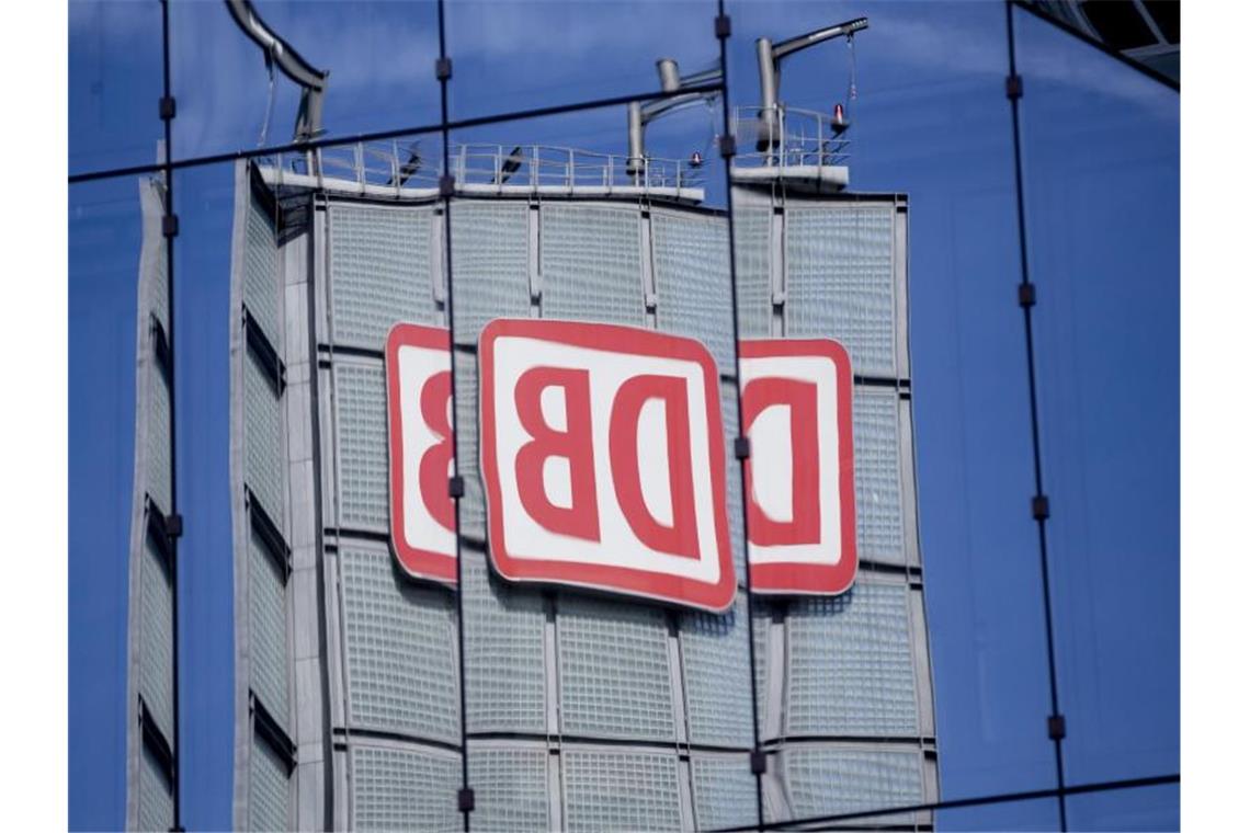 Das Logo der Deutschen Bahn AG spiegelt sich in Berlin in einer Gebäudefassade. Foto: Christoph Soeder/dpa