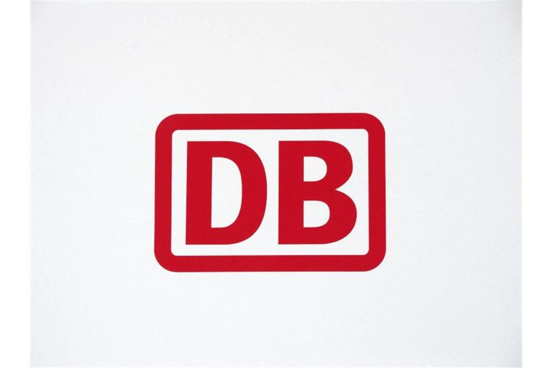 Das Logo der Deutschen Bahn ist in roten Buchstaben auf weißem Hintergrund zu sehen. Foto: Ralf Hirschberger/dpa/Archivbild