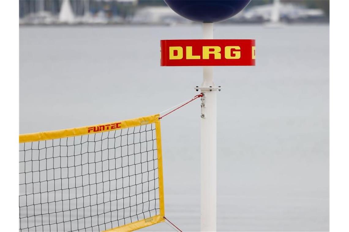 DLRG-Lebensretter: Menschen unterschätzen Überflutungen Das Logo der Deutschen Lebens-Rettungs-Gesellschaft (DLRG) ist an einem Mast am Strand befestigt. Foto: Frank Molter/dpa/Symbolbild