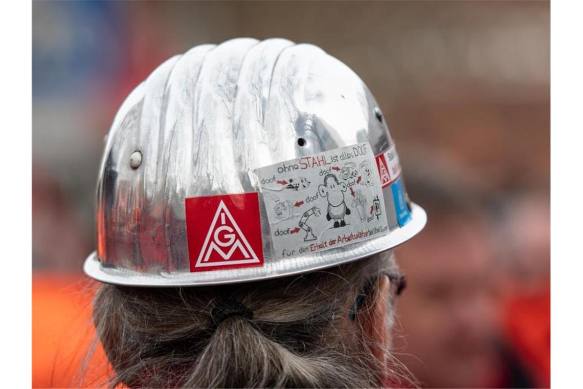 Das Logo der IG Metall auf dem Helm eines Stahlarbeiters. Foto: Bernd Thissen/dpa