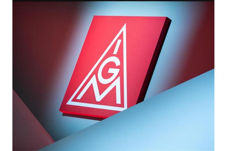 Das Logo der IG Metall hängt über einer Bühne. Foto: Daniel Karmann/dpa/Symbolbild