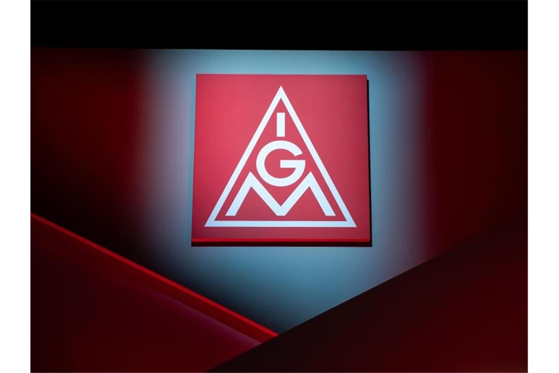 Das Logo der IG Metall hängt über einer Bühne. Foto: Daniel Karmann/dpa/Symbolbild