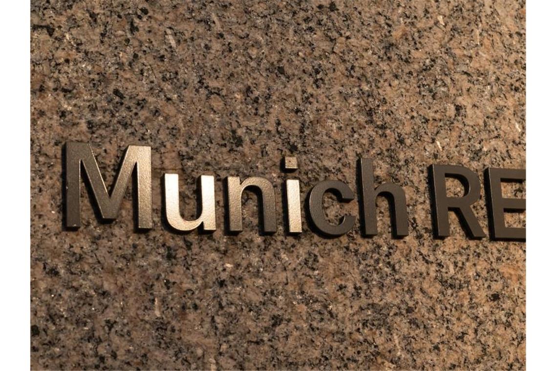 Munich Re hält trotz hoher Hochwasser an Gewinnziel fest Das Logo der Munich RE klebt an der Mauer vor dem Haupteingang des Verwaltungsgebäudes der Münchener Rückversicherungs-Gesellschaft AG (Munich Re) im Münchner Stadtteil Schwabing. Foto: Peter Kneffel/dpa