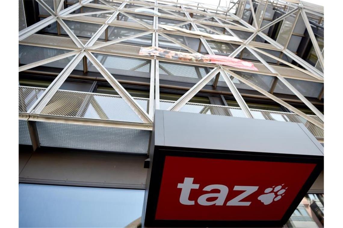 Das Logo der Tageszeitung „taz“ ist am Eingang des Redaktionsgebäudes in Berlin-Mitte zu sehen. Foto: Sven Braun/dpa