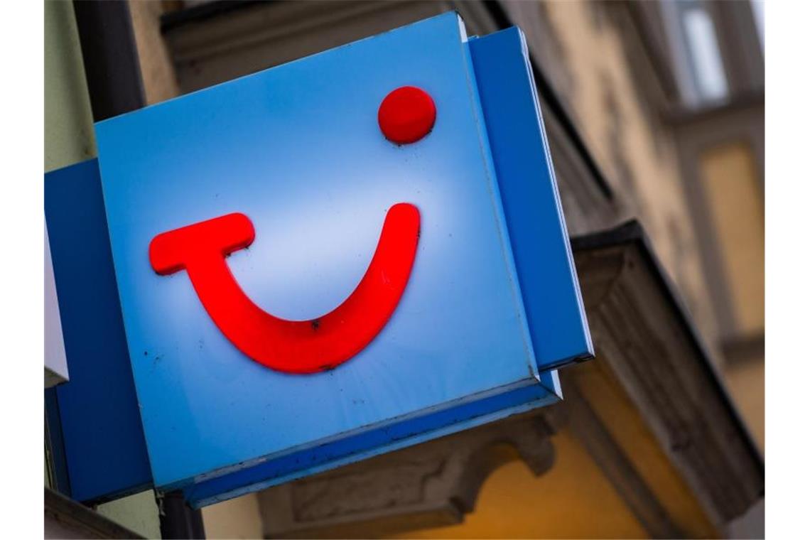 Das Logo des Reiseunternehmens TUI ist an der Fassade eines Reisehändlers angebracht. Foto: Nicolas Armer/dpa
