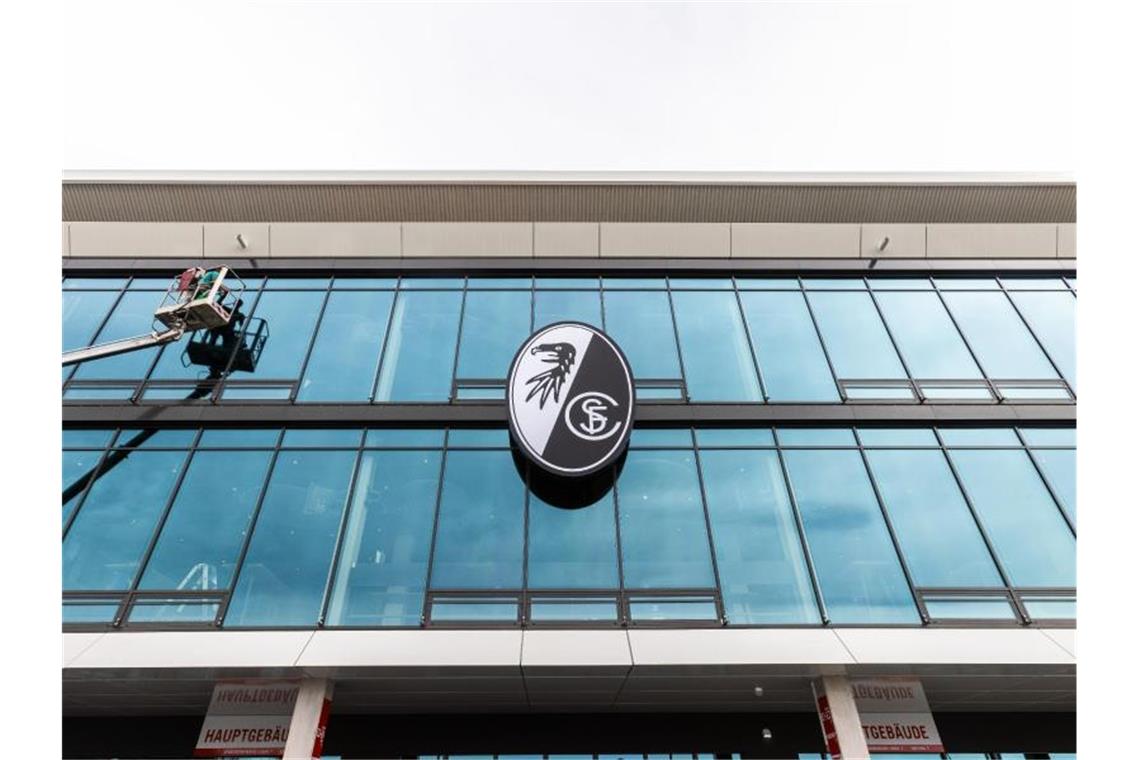 Das Logo des SC Freiburg hängt über dem Eingang des neuen Stadions. Foto: Philipp von Ditfurth/dpa/Archivbild