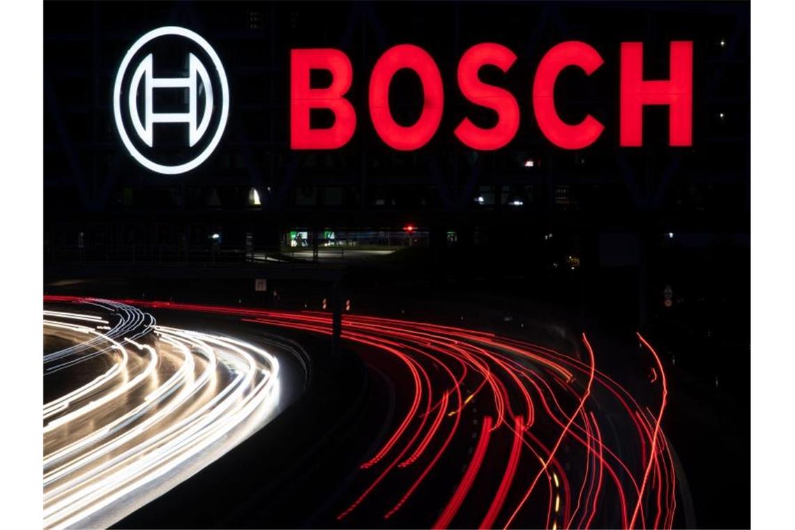 Das Logo des Technologiekonzerns Bosch leuchtet über einem Parkhaus. Foto: Marijan Murat/dpa