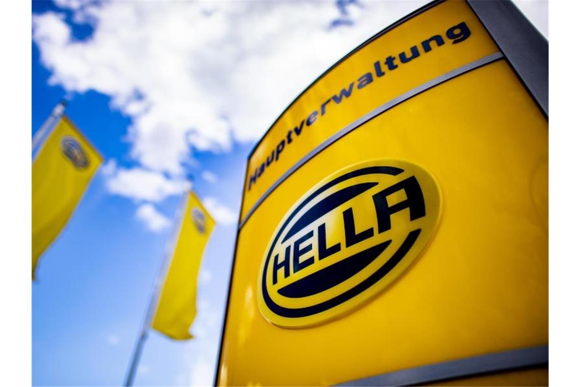 Das Logo des Unternehmens steht vor der Zentrale des Automobilzulieferers "Hella". Foto: David Inderlied/dpa