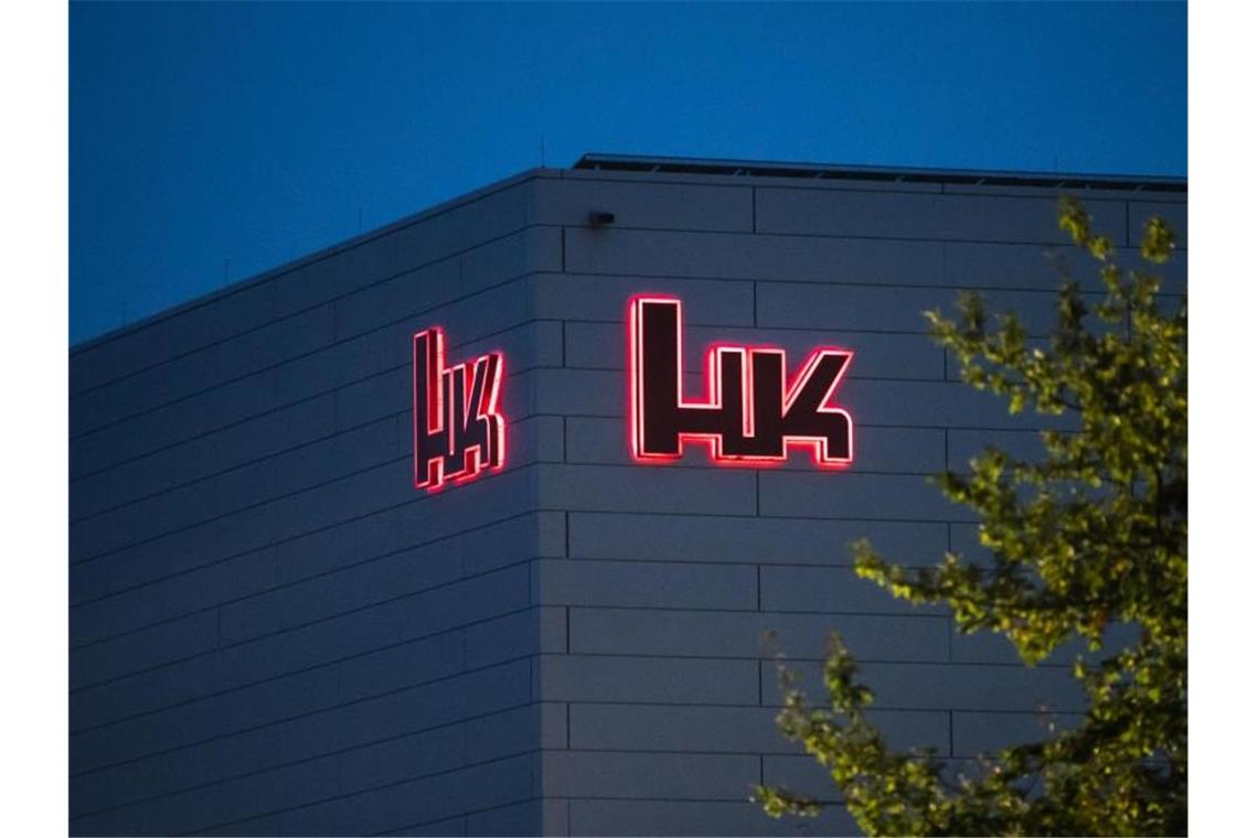 Streit mit Heckler & Koch: Haenel steht vor Niederlage Das Logo des Waffenherstellers Heckler & Koch leuchtet bei Tagesanbruch. Foto: Silas Stein/dpa/Archivbild
