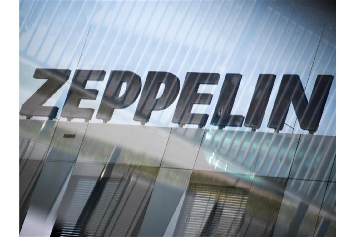 Das Logo des Zeppelin Konzerns ist durch eine Glasscheibe zu sehen. Foto: Felix Kästle/dpa/Symbolbild
