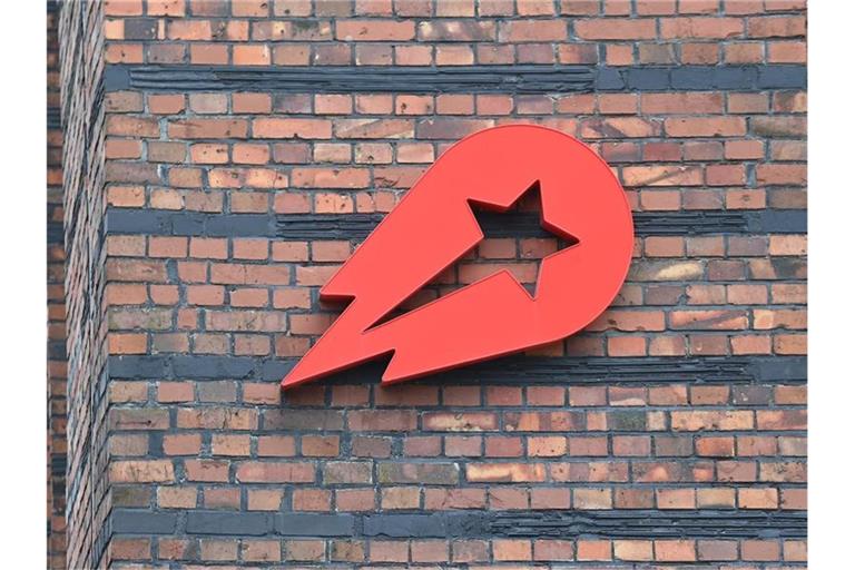 Das Logo Essenslieferdienstes Delivery Hero ist an einer Wand der Zentralein Berlin angebracht. Foto: Britta Pedersen/dpa-Zentralbild/dpa