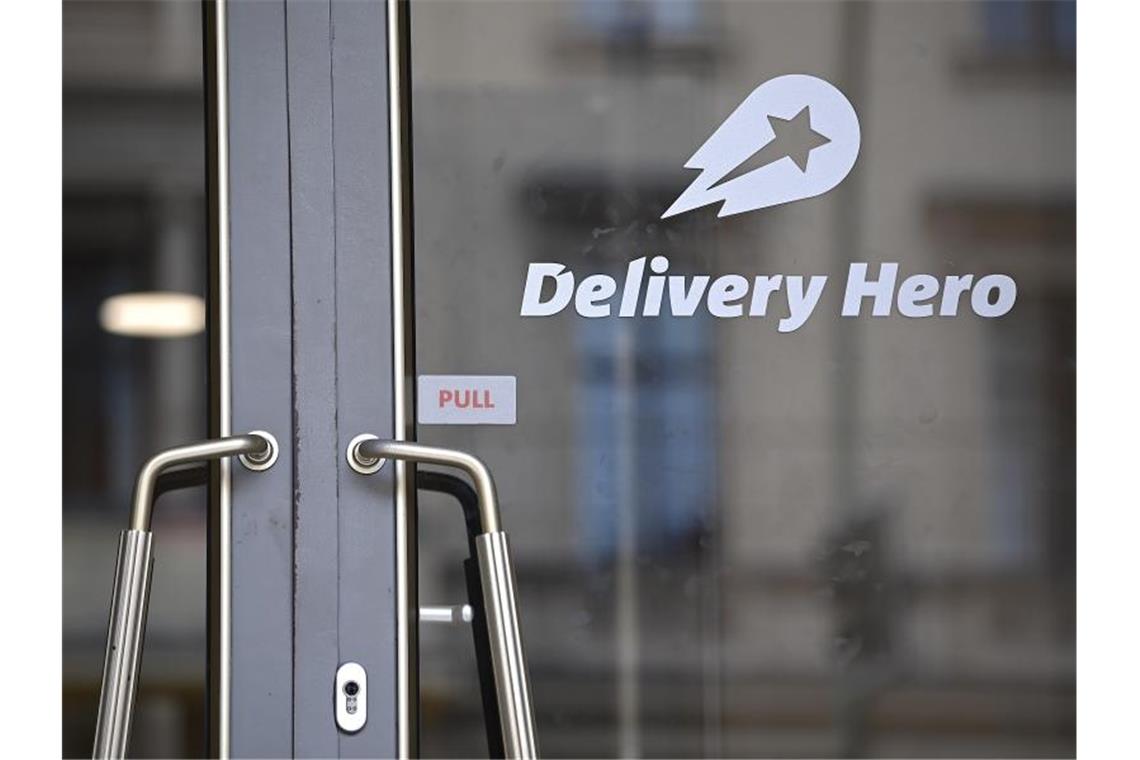 Das Logo Essenslieferdienstes Delivery Hero ist an einer Glasscheibe der Zentrale angebracht. Foto: Britta Pedersen/dpa-Zentralbild/dpa