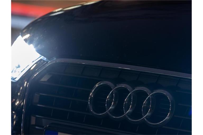 Das Logo vom Automobilhersteller Audi ist am Abend an einem Fahrzeug zu sehen. Foto: Moritz Frankenberg/dpa/Archivbild