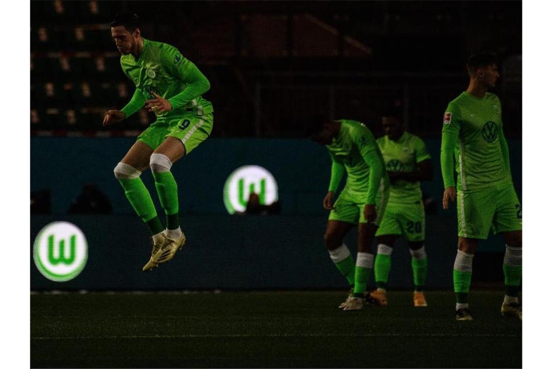 Das Logo vom VfL Wolfsburg leuchtet vor Spielbeginn auf Werbebanden, während die Spieler das Spielfeld betreten. Foto: Swen Pförtner/dpa