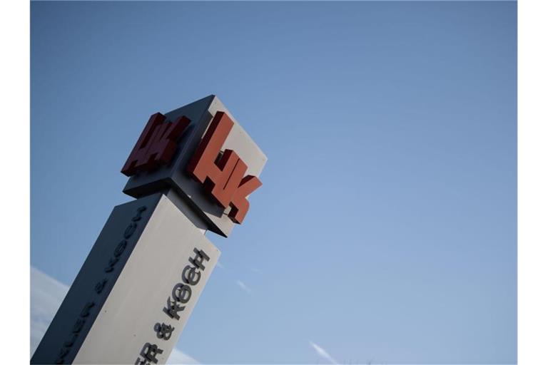 Das Logo von Heckler & Koch auf einer Anzeige vor dem Firmengelände des Unternehmens. Foto: Marijan Murat/dpa/Archivbild