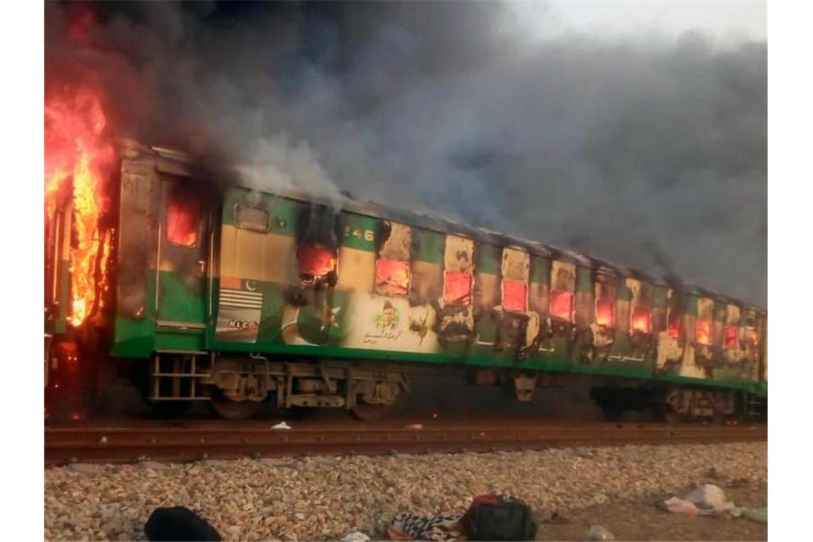 Mehr als 70 Tote bei Feuer-Inferno in pakistanischem Zug Das mit einem Mobiltelefon aufgenommene Foto zeigt den Brand eines Personenzuges in Pakistans östlicher Punjab-Provinz. Foto: Str/XinHua/dpa