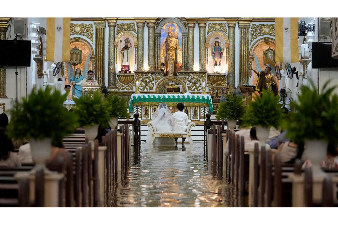 Philippinen: Paar watet in überfluteter Kirche zum Jawort Das Paar hatte die Kirche in Malolos schon vor zwei Jahren gebucht.