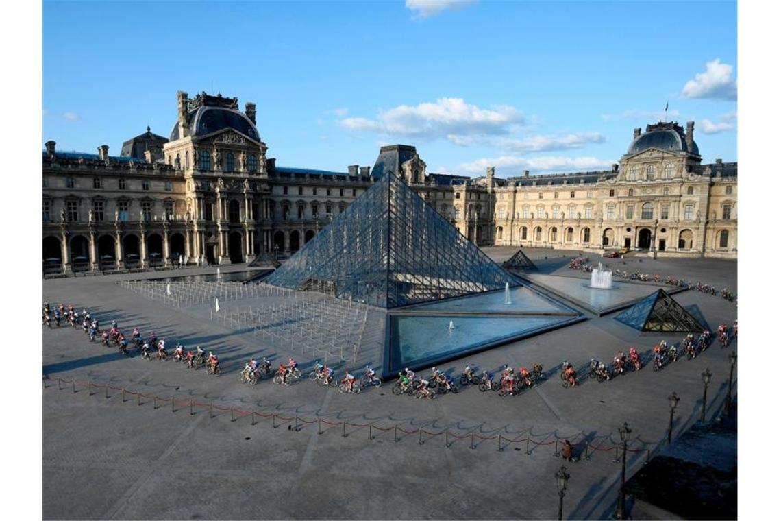 Bernal schreibt Tour-Geschichte - Buchmann hat „Appetit“ Das Peloton passiert die Glaspyramide im Innenhof des Louvre-Museums. Foto: Lionel Bonaventure/POOL AFP/AP