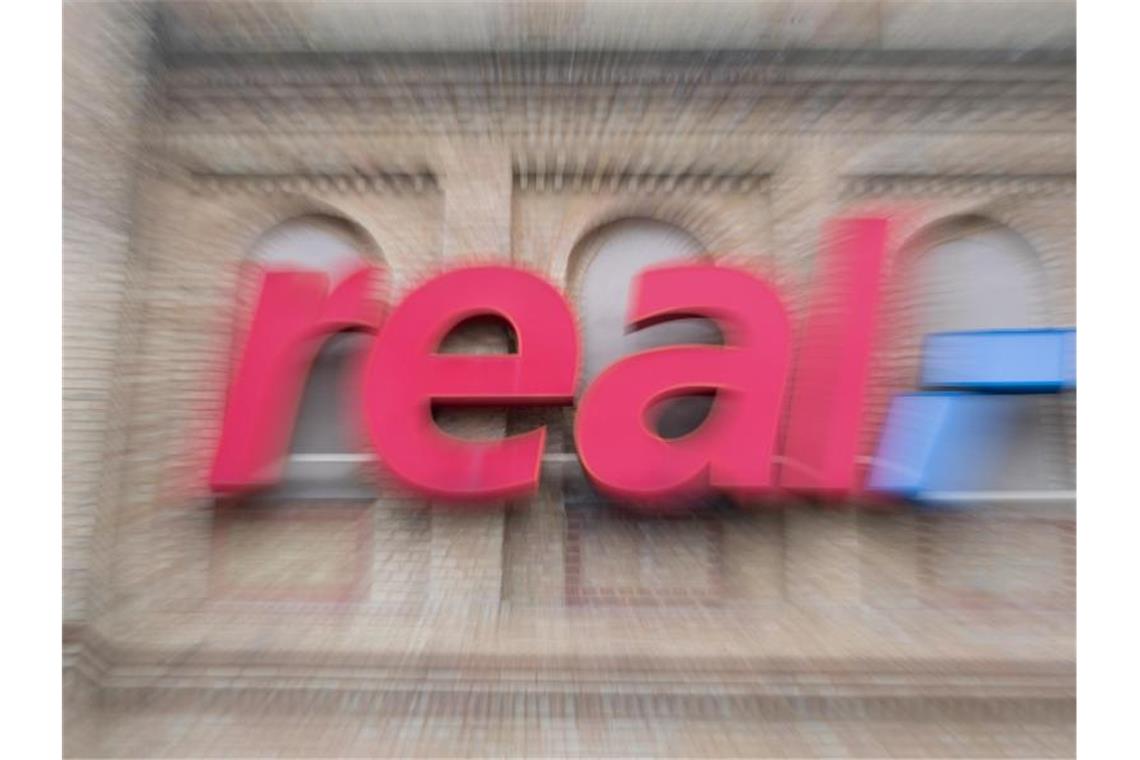 Das „Real“-Logo ist auf der Fassade eines Real-Supermarktes zu sehen. Foto: Friso Gentsch/dpa/Symbolbild