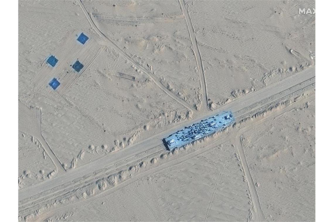Das Satellitenbild zeigt ein Gebäude auf Bahngleisen in der Ruoqiang-Gegend der Taklamakan-Wüste. Foto: Uncredited/Maxar Technologies/AP/dpa