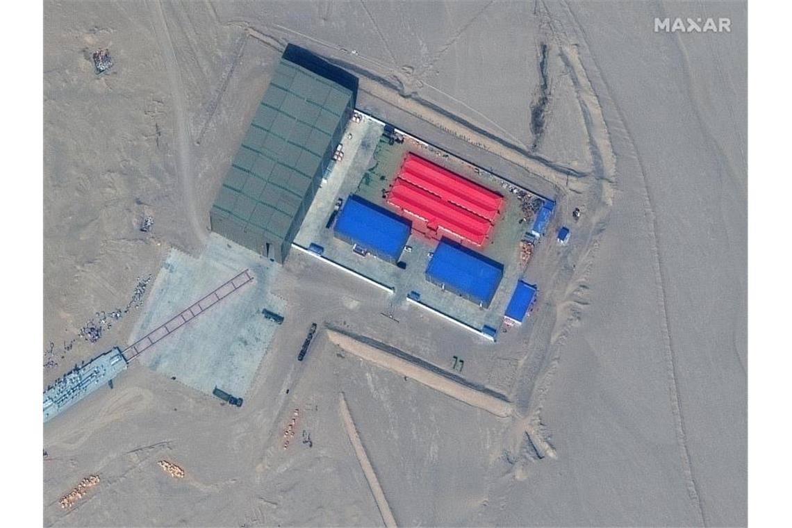 Das Satellitenbild zeigt ein Schienenterminal und ein Ziellagergebäude. Das chinesische Militär hat nach US-Angaben Attrappen Kriegsschiffe der USA für mögliche Zielübungen in der Wüste gebaut. Foto: Uncredited/Maxar Technologies/AP/dpa