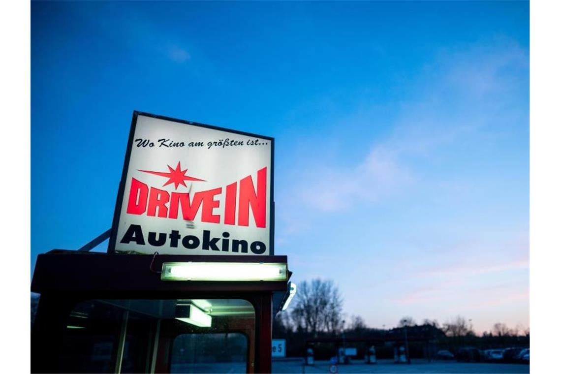 Das Schild eines Drive-In Autokinos leuchtet in der Nähe von Essen. Foto: Fabian Strauch/dpa