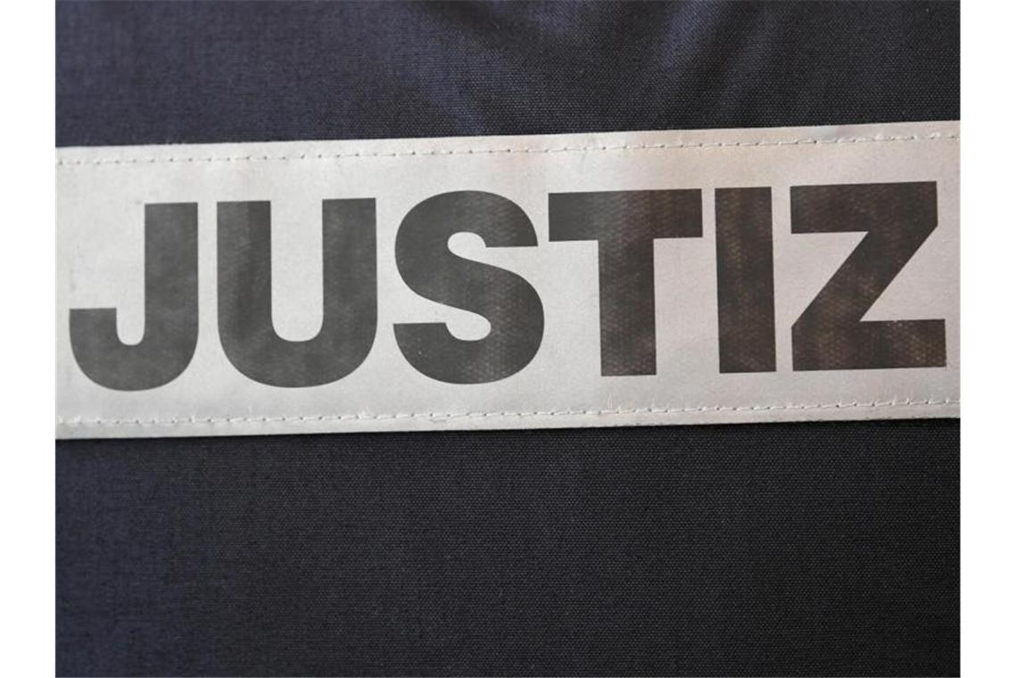 „Sie sind ein freier Mann“: Prozess um Gruppenvergewaltigung Das Schild eines Justizbeamten, der im Gerichtssaal des Landgerichts steht, ist an seiner Kleidung befestigt. Foto: Patrick Seeger/Archiv