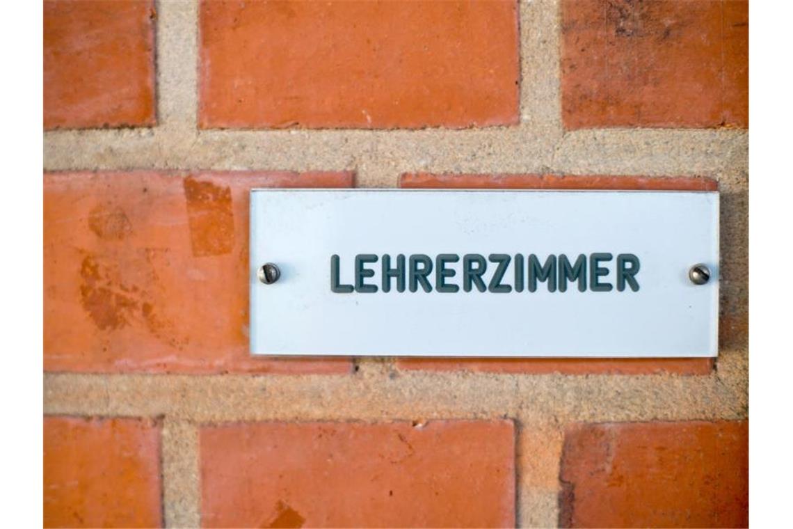 Das Schild „Lehrerzimmer“ ist in einer Schule an einer Wand angebracht. Foto: Daniel Karmann/dpa/Archivbild