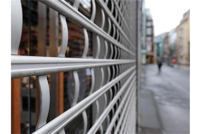 Das Schutzgitter eines geschlossenen Modegeschäftes in der Innenstadt. Foto: Sebastian Willnow/dpa-Zentralbild/dpa