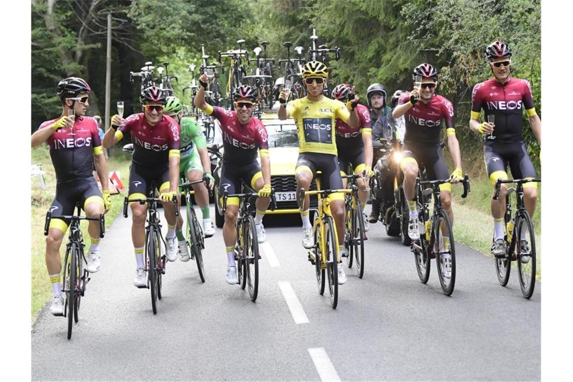 Bernal schreibt Tour-Geschichte - Buchmann hat „Appetit“ Das Team Ineos um Egan Bernal (M) gönnt sich zum Abschluss der kräftezehrenden Tour ein Glas Champagner. Foto: Pool Peter De Voecht/BELGA