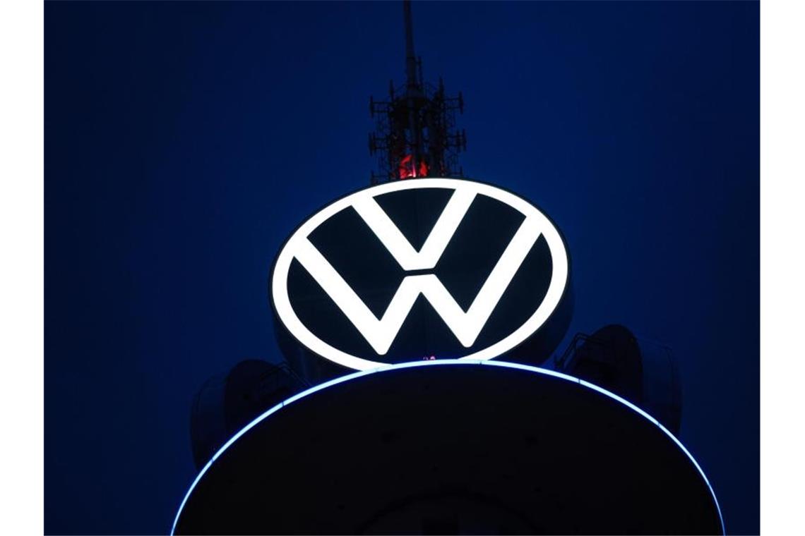 Boni bei VW sollen Umwelt- und Sozialziele berücksichtigen Das Volkswagen Logo leuchtet auf dem VW-Tower vor dunklem Himmel. Foto: Ole Spata/dpa
