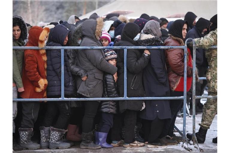 Das von der belarussischen Staatsagentur BelTA zur Verfügung gestellte Foto zeigt Migranten, die in einem Logistikzentrum an der belarussisch-polnischen Grenze für Essen anstehen. Foto: Oksana Manchuk/BelTA/AP/dpa