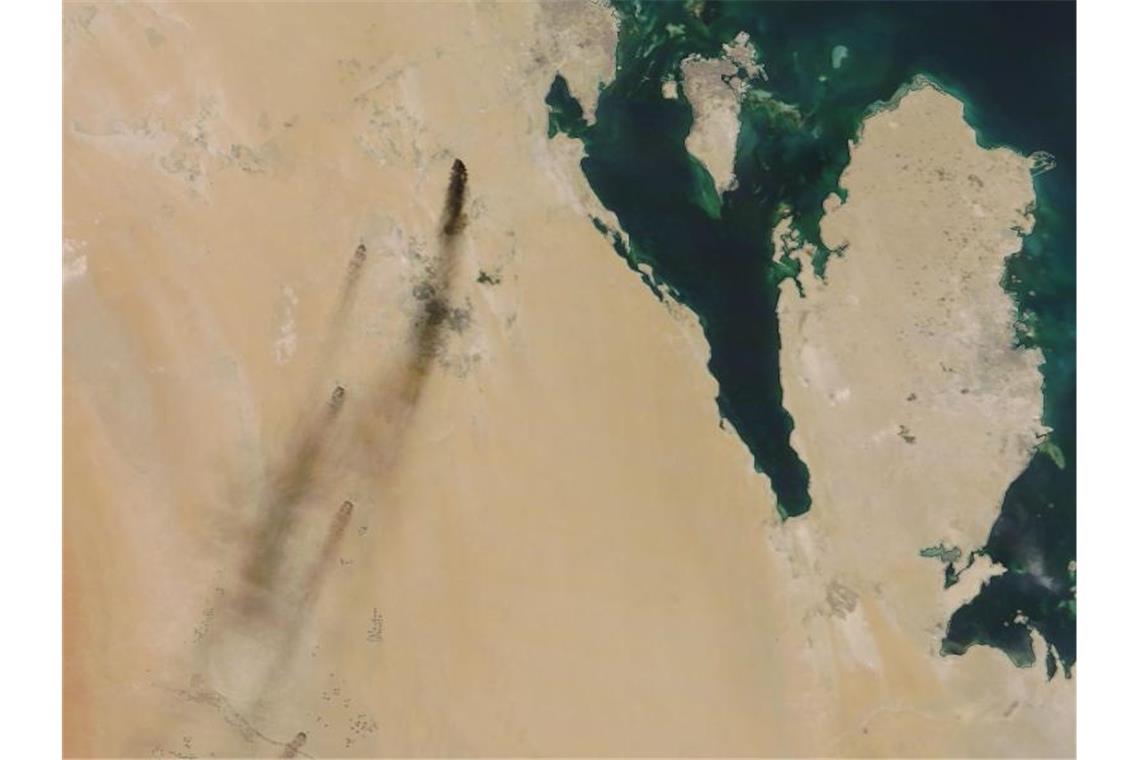 Das von der NASA Worldview zur Verfügung gestellte Satellitenbild zeigt die aus Ölfeldern aufsteigenden Rauchwolken. Foto: NASA Worldview/AP