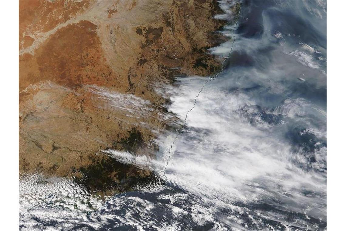 Feuerwehr kämpft bei Sydney gegen „Megafeuer“ Das von der NASA zur Verfügung gestellte Bild zeigt Rauchschwaden der Buschfeuer in New South Wales. Foto: --/NASA/dpa