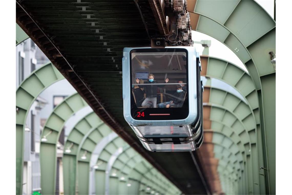 Das Wahrzeichen der Stadt Wuppertal, die Schwebebahn fährt über der Kaiserstraße in Vohwinkel entlang. Foto: Jonas Güttler/dpa