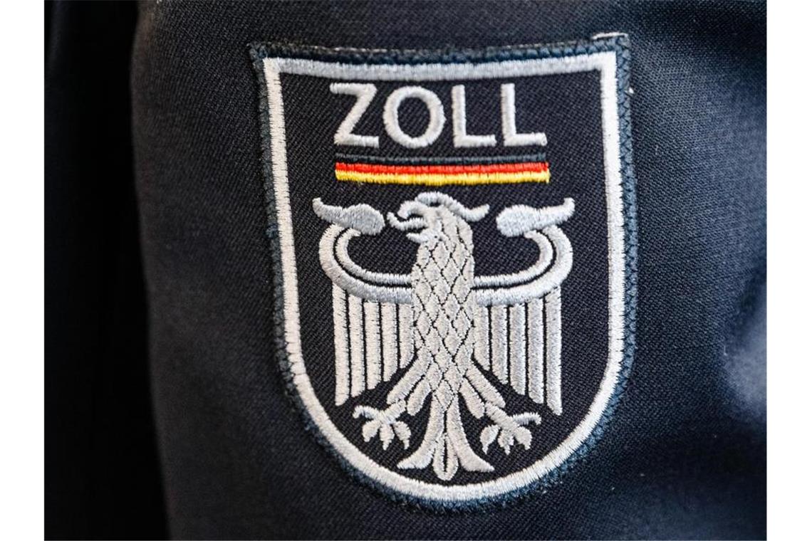 Das Wappen des Zolls mit den Bundesfarben ist auf der Uniform eines Beamten angebracht. Foto: Markus Scholz/dpa/Archivbild