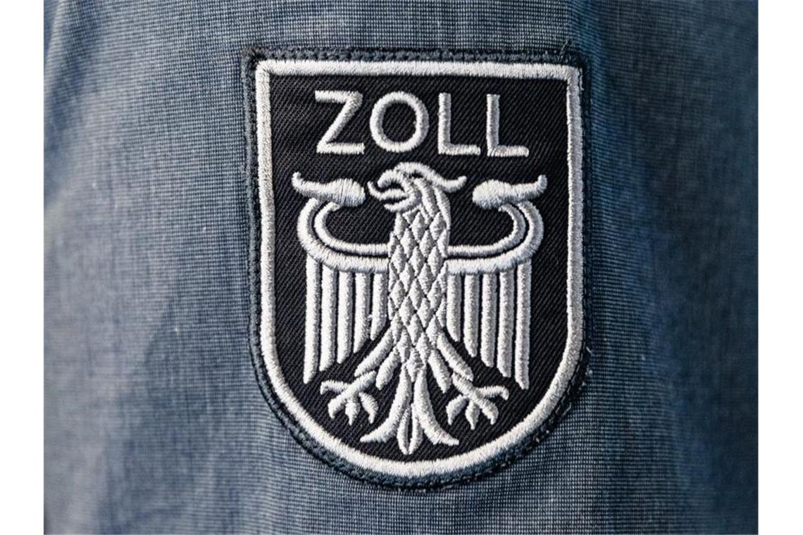 Das Wappen des Zolls ohne die Bundesfarben ist auf der Arbeitsuniform eines Beamten angebracht. Foto: Markus Scholz/dpa/Archiv