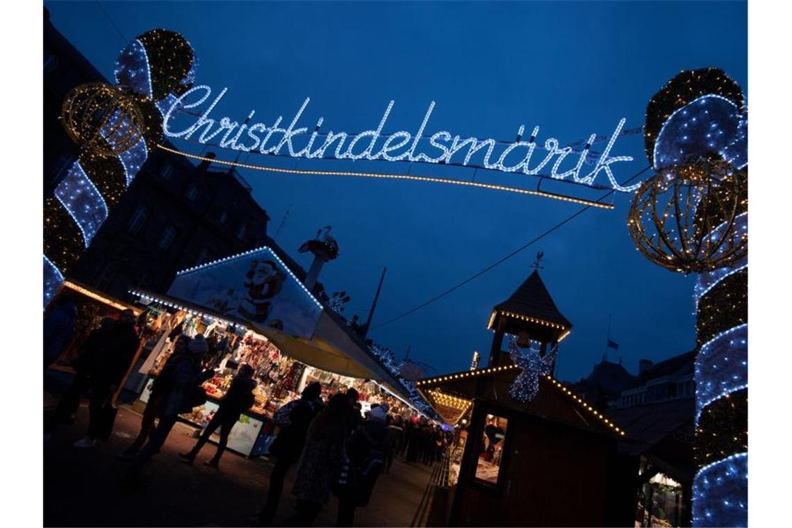 Das Wort „Christkindelsmärik“ prangt in beleuchteten Buchstaben an einem Zugang zum Weihnachtsmarkt. Foto: Marijan Murat/dpa/Archiv