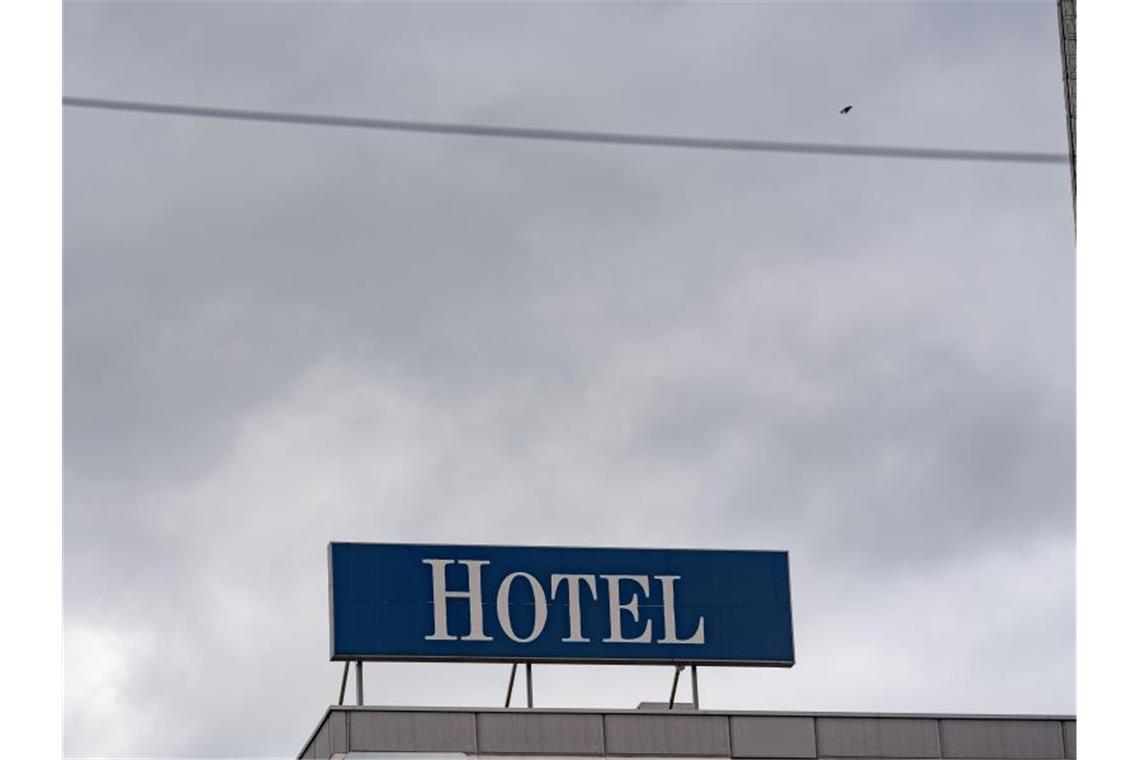 Das Wort „Hotel“ steht auf einer Leuchttafel auf einem Hotel. Foto: Frank Rumpenhorst/dpa/Archiv
