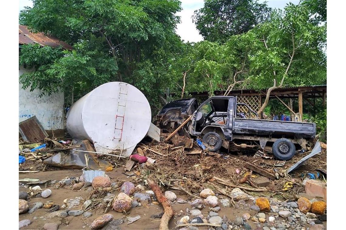 Fast 130 Tote nach Unwettern in Indonesien Das Wrack eines Pick-ups liegt nach einem Unwetter auf einem Haufen Trümmern. Foto: Rofinus Monteiro/AP/dpa
