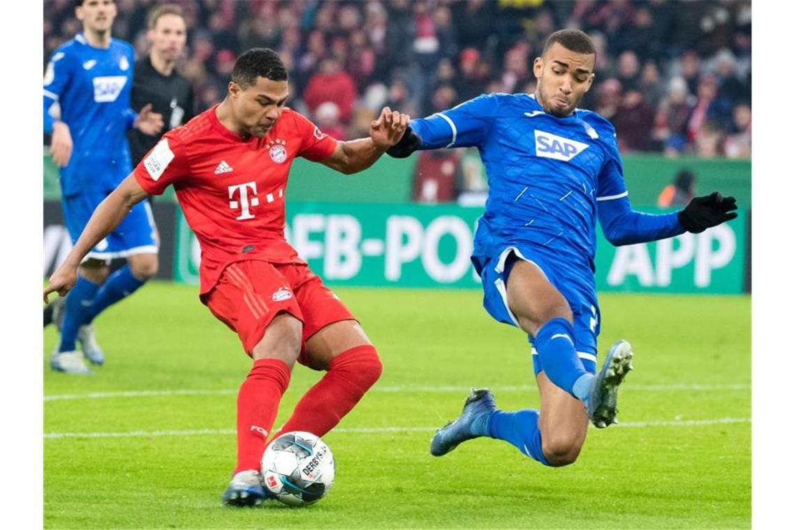 David Alaba (l) und Kevin Akpoguma im Zweikampf um den Ball. Foto: Matthias Balk/dpa