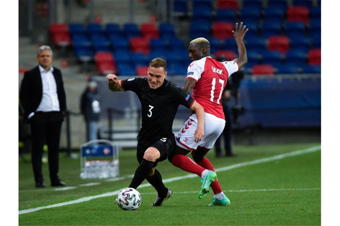 David Raum (l) gewinnt den Zweikampf mit Mohamed Daramy. Foto: Marton Monus/dpa