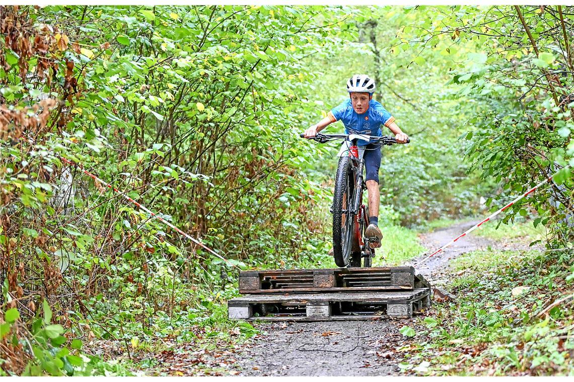 David Rehrauer (Nr. 59) springt über das Hindernis im Wald. 4. Kindercrossduathl...