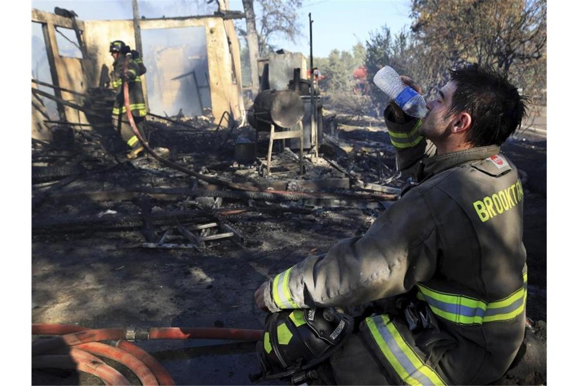 David Wells vom Brooktrails Township Fire Department in Willits trinkt Wasser, nachdem er die Flammen in einem Haus gelöscht hat. Foto: Kent Porter/The Press Democrat/AP/dpa