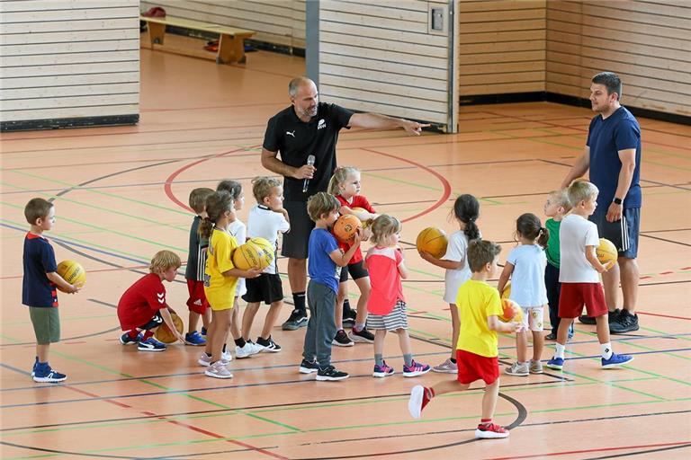 Davide Tortorelli (Mitte) zeigt dem Backnanger Nachwuchs, wie toll Bewegung mit dem Basketball von klein auf sein kann. Foto: Alexander Becher