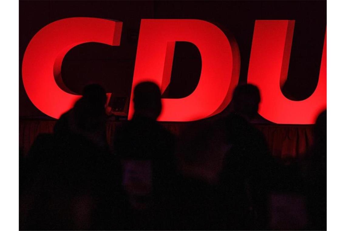 Delegierte sitzen vor dem CDU-Parteilogo. Foto: Swen Pförtner/dpa/Symbolbild