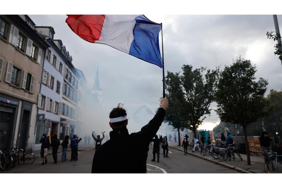 Demo in Straßburg: Ein Demonstrant hält eine französische Flagge hoch.